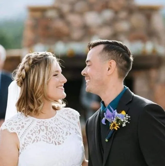 Bride with a braided half-up wedding style beside her groom