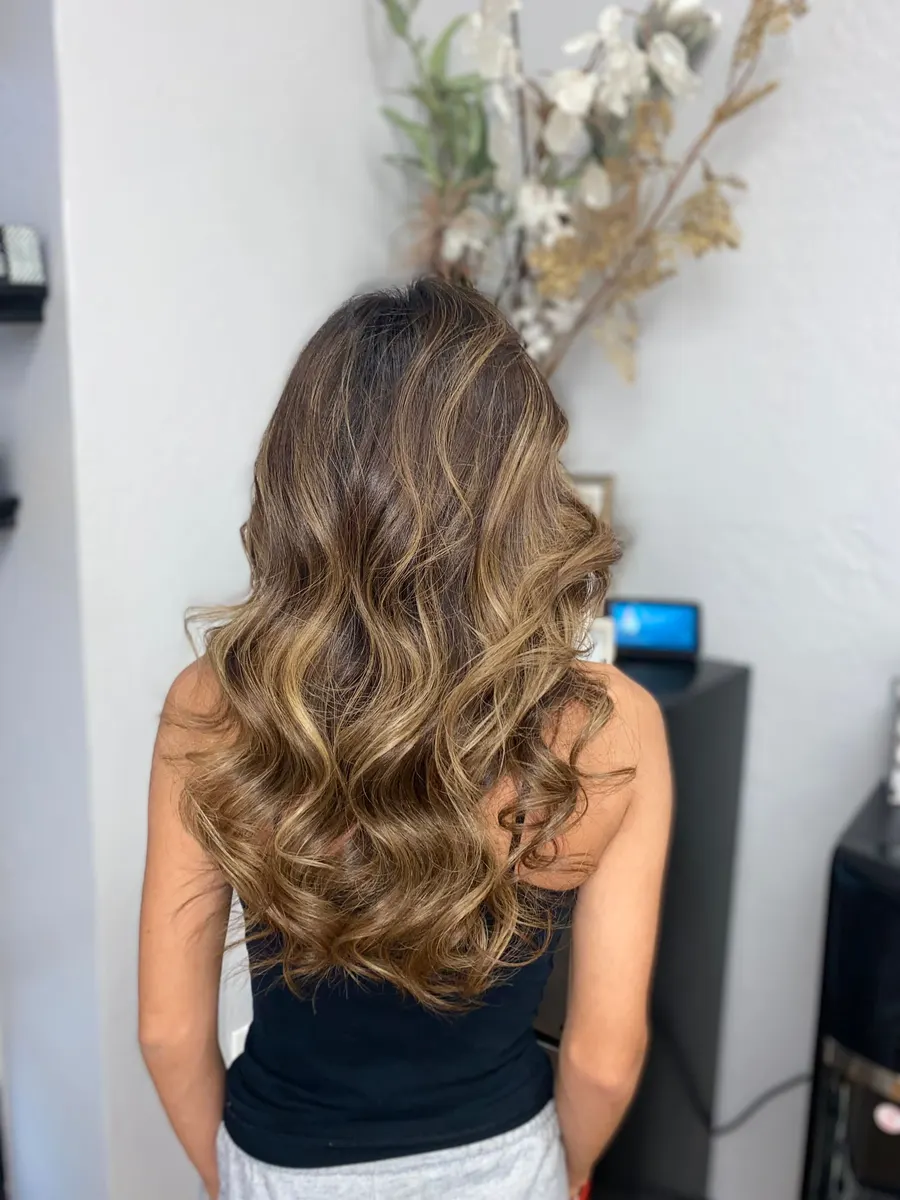 Warm bronze balayage with soft curled ends, finished at Hair House
